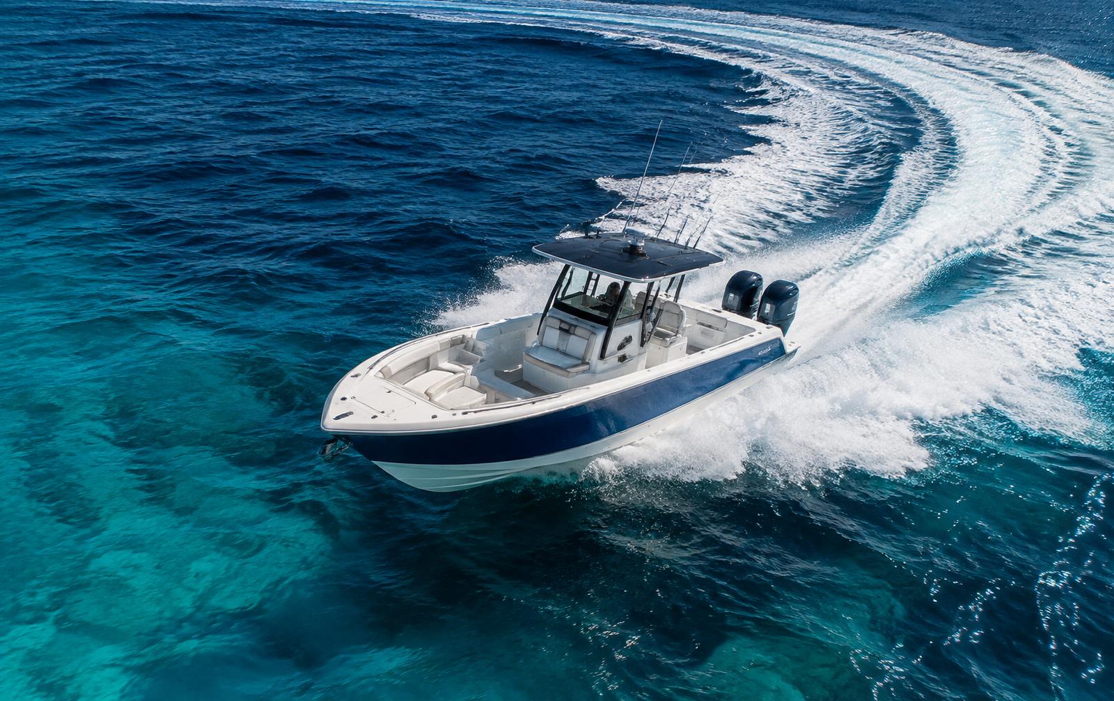 Premium twin-engine open boat carving a turn on clear offshore water
